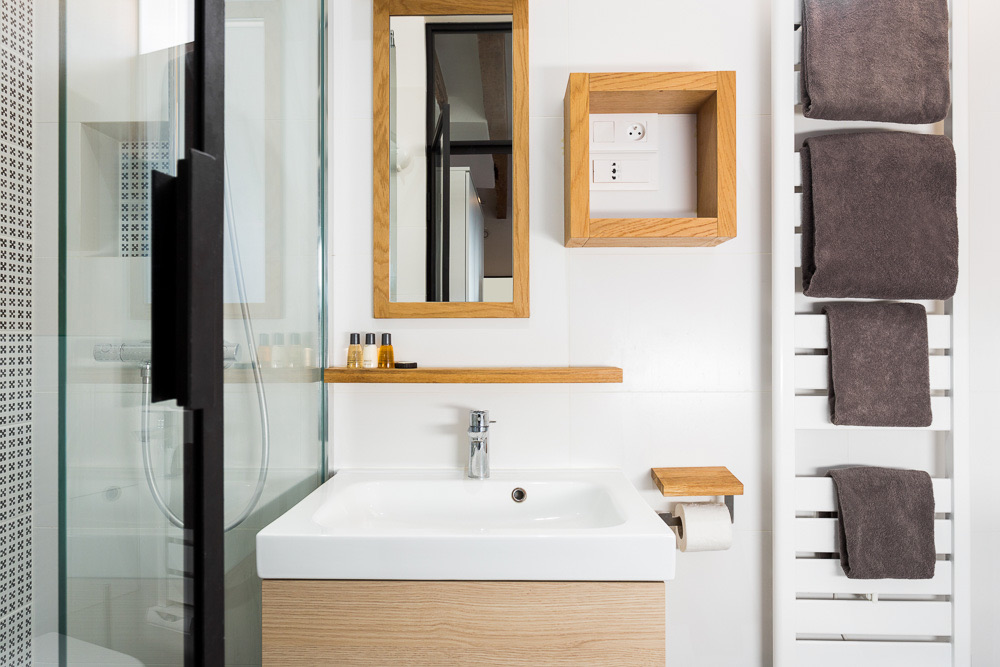 Salle de bain avec douche vitrée, vasque sur meuble en bois clair et miroir en chêne