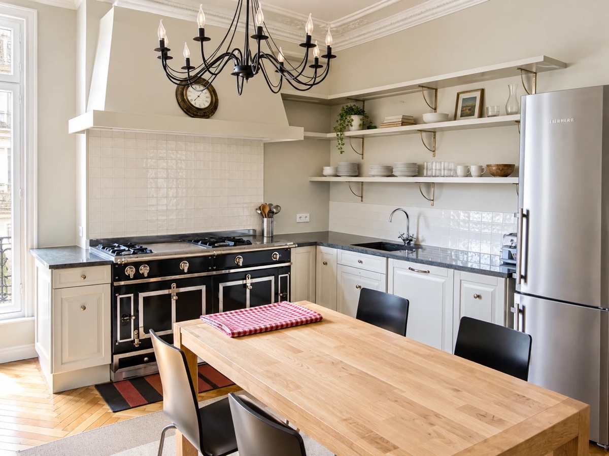 Cuisine haussmannienne avec piano de cuisson noir et grande table en bois