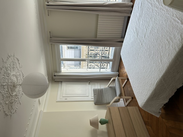 Chambre haussmannienne avec moulures, parquet et balcon en fer forgé