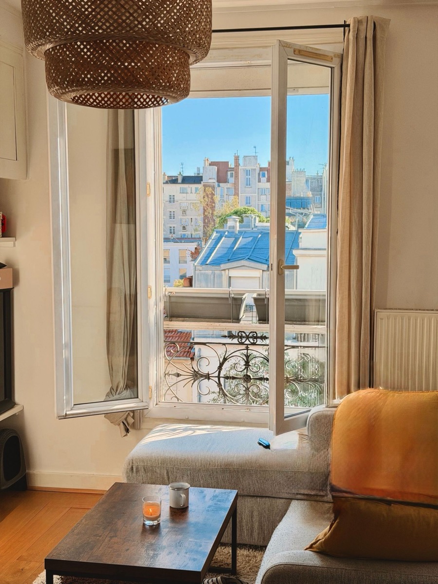 Salon d'un appartement parisien, fenêtre ouverte sur les toits